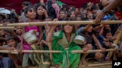 Sejumlah anak-anak etnis Rohingya, yang pergi menyeberang ke Bangladesh dari Myanmar, tampak saling berdempetan ketika menunggu bantuan makanan di kamp pengungsi Thaingkhali, Bangladesh, pada 21 Oktober 2017. (Foto: AP/Dar Yasin)