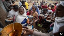 FILE - Tigrayans queue to receive food donated by local residents at a reception center for the internally displaced, in Mekele, in Ethiopia's Tigray region, May 9, 2021. 