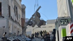 Rescue workers clear the rubble of a building of the Kharkiv Regional Institute of Public Administration damaged by shelling, March 18, 2022, amid Russia's invasion of Ukraine.