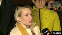 Marina Ovsyannikova, a Channel One employee who staged an on-air protest as she held up a anti-war sign behind a studio presenter, speaks to the media as the leaves the court building in Moscow, Russia March 15, 2022 in this still image taken from a video.