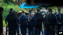 A relative of passengers onboard the China Eastern Flight 5735 cries as she is escorted near the crash site, March 24, 2022, in Shentian village, southwestern China's Guangxi province.