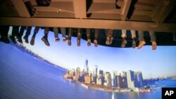 FILE - People ride an indoor tourist attraction called RiseNY just off Times Square in Manhattan's Theater District in New York City, March 1, 2022. A U.S. Census Bureau study shows nearly 3,000 U.S. counties saw a population drop in 2021. 