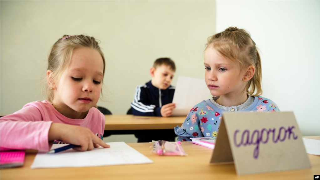 Two children attend a class for refugees from Ukraine in Berlin, Germany, Monday, March 21, 2022. (AP Photo/Markus Schreiber)