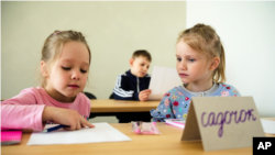 Two children attend a class for refugees from Ukraine in Berlin, Germany, Monday, March 21, 2022. (AP Photo/Markus Schreiber)