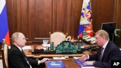 FILE - Russian President Vladimir Putin, left, listens to ROSNANO CEO Anatoly Chubais during their meeting in Moscow, Russia, March 19, 2019. 