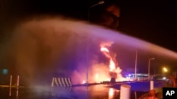 In this photo provided by the Saudi Press Agency, firefighters try to extinguish a blaze at an Aramco terminal in the southern border town of Jizan, Saudi Arabia, early Sunday, March 20, 2022. (Saudi Press Agency via AP)