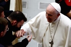 El Papa Francisco interactúa con los participantes después de un curso de estudio sobre el sacramento de la penitencia en el Aula Pablo VI, en el Vaticano, el 25 de marzo de 2022