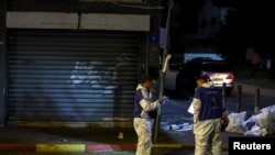 Israeli police forensics experts work at the scene of an attack in which people were killed by gunmen on a main street in Hadera, Israel, March 27, 2022