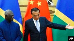 FILE - Solomon Islands Prime Minister Manasseh Sogavare, left, and Chinese Premier Li Keqiang attend a signing ceremony at the Great Hall of the People in Beijing, Oct. 9, 2019.