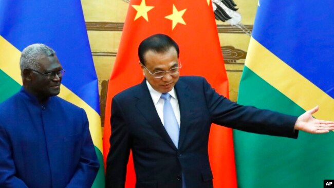 FILE - Solomon Islands Prime Minister Manasseh Sogavare, left, and Chinese Premier Li Keqiang attend a signing ceremony at the Great Hall of the People in Beijing, Oct. 9, 2019.