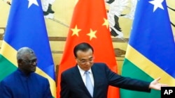 FILE - Solomon Islands Prime Minister Manasseh Sogavare, left, and Chinese Premier Li Keqiang attend a signing ceremony at the Great Hall of the People in Beijing, Oct. 9, 2019.