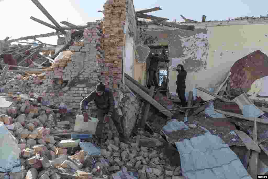 Locales limpian los escombros del centro cultural destruido en los bombardeos a principios de este mes, en el pueblo de Byshiv en las afueras de Kiev.
