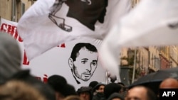 FILE - In this file photo taken on March 13, 2022 in Bastia, protesters hold a banner depicting Yvan Colonna during a rally in support to the Corsican nationalist figure, a week after he was attacked in prison in Arles.