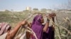 Somali women who fled drought-stricken areas start to build shelters at a makeshift camp on the outskirts of the capital Mogadishu, Somalia, Feb. 4, 2022.