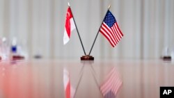 Bendera Singapura dan bendera Amerika dipasang di atas meja pertemuan Menhan AS Lloyd Austin dengan PM SIngapura Lee Hsien Loong di Pentagon, Washington, 28 Maret 2022. (AP/Andrew Harnik)
