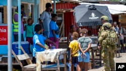 FILE - Australian Army soldiers talk with local citizens during a community engagement patrol through Honiara, Solomon Islands, Nov. 27, 2021. A leaked document indicates that China could boost its military presence in the Solomon Islands in a developmen