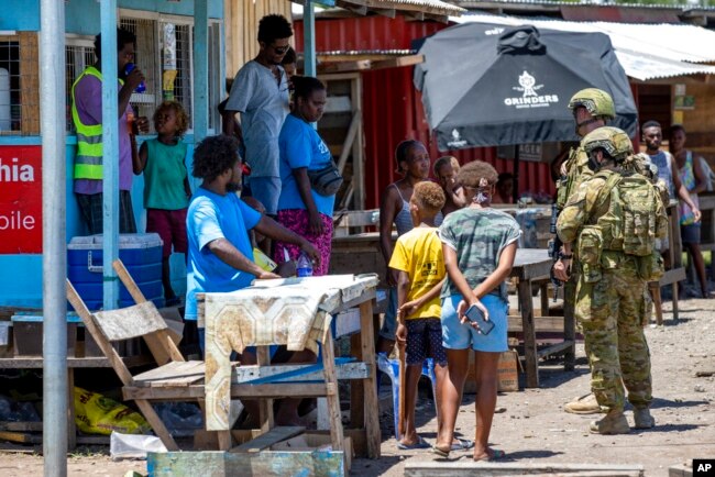 FILE - Australian Army soldiers talk with local citizens during a community engagement patrol through Honiara, Solomon Islands, Nov. 27, 2021. A leaked document indicates that China could boost its military presence in the Solomon Islands. (Cpl. Brandon Grey/Department of Defence via AP, File)