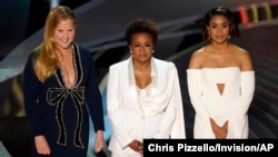 Hosts Amy Schumer, from left, Wanda Sykes, and Regina Hall appear on stage at the Oscars, March 27, 2022, at the Dolby Theatre in Los Angeles.