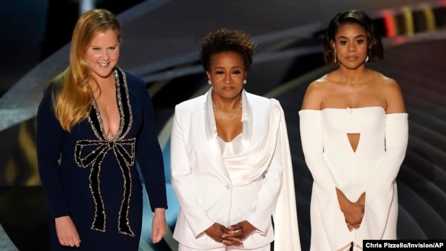 Hosts Amy Schumer, from left, Wanda Sykes, and Regina Hall appear on stage at the Oscars, March 27, 2022, at the Dolby Theatre in Los Angeles.