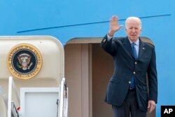 President Joe Biden waves as he boards Air Force One at Andrews Air Force Base, Md., March 23, 2022.