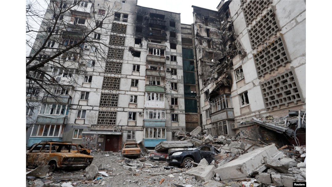 Destroyed cars are seen in front of an apartment building which was heavily damaged during Ukraine-Russia conflict in the besieged southern port city of Mariupol, March 27, 2022.