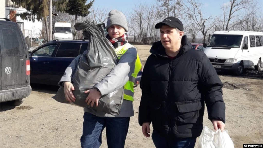 特伦特和儿子西姆为在罗马尼亚边界为乌克兰难民分发物资。（来源：2feetin.org）(photo:VOA)
