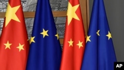 FILE - In this file photo dated Dec. 17, 2019, EU and Chinese flags at the Europa building in Brussels.