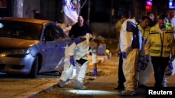 Israeli police forensics experts work at the scene of an attack in which people were killed by gunmen on a main street in Hadera, Israel, March 27, 2022.