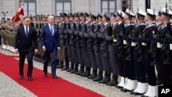 U.S. President Joe Biden walks past an honor guard with Polish President Andrzej Duda, at the Presidential Palace, in Warsaw, Poland, March 26, 2022.