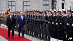 U.S. President Joe Biden walks past an honor guard with Polish President Andrzej Duda, at the Presidential Palace, in Warsaw, Poland, March 26, 2022.