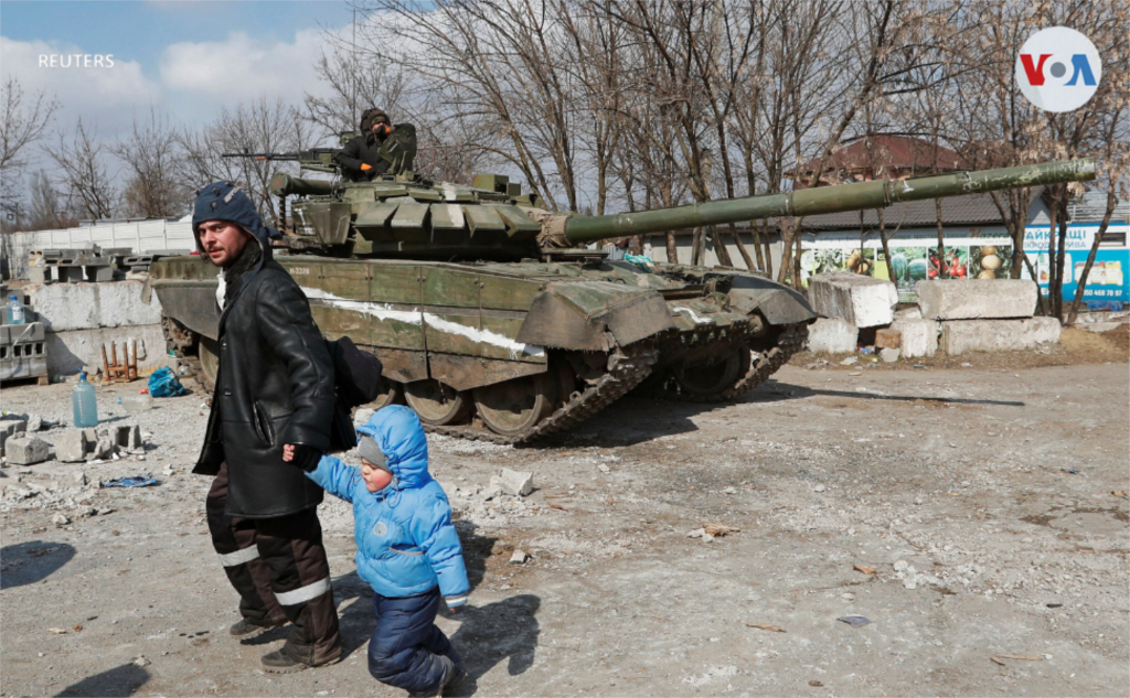 Ubicada al sureste de Ucrania, Mariúpol es una ciudad portuaria y una de las más afectadas tras la invasión. En la foto, un hombre y un niño pasan frente a un tanque de tropas prorrusas.