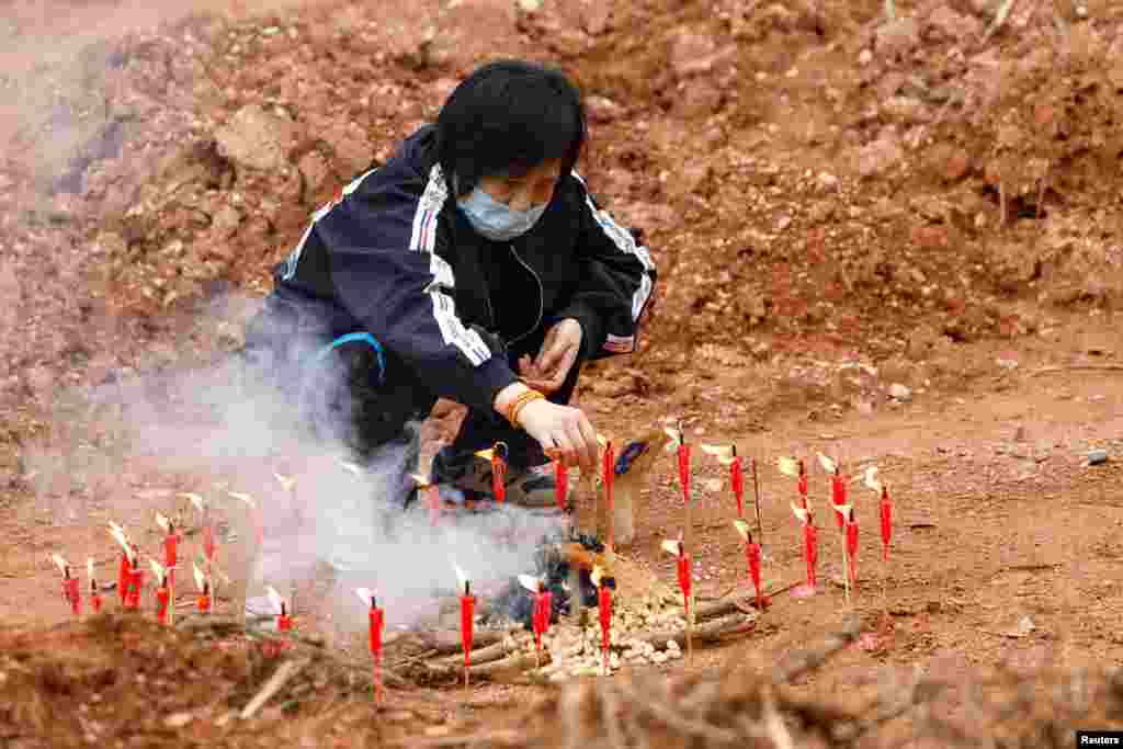 A woman takes part in a Buddhist ceremony in honor of the victims in a field close to the site where a China Eastern Airlines Boeing 737-800 plane crashed, in Wuzhou, Guangxi Zhuang Autonomous Region.