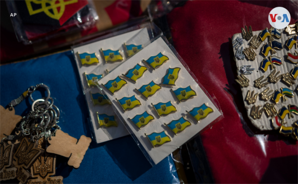 Pines con el azul y amarillo de la bandera de Ucrania se venden en el mercado de la ciudad.