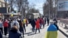 Demonstrators, some displaying Ukrainian flags, chant 'go home' while Russian military vehicles reverse course on the road, at a pro-Ukraine rally amid Russia's invasion, in Kherson, March 20, 2022 in this still image from video obtained by Reuters. 