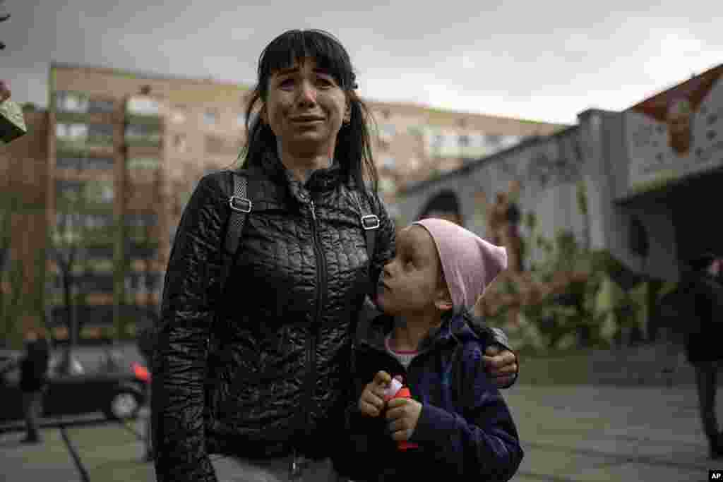 Julia, 34, cries next to her daughter Veronika, 6, while talking to the press in Brovary, on the outskirts of Kyiv, Ukraine.