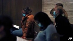 FILE - Sofiya Bidochko, left, a 19-year-old student from Lviv, Ukraine, sits in the pews of St. Thomas More Catholic Chapel during a benefit concert for Ukraine at Yale University in New Haven, Conn., Wednesday, March 16, 2022.