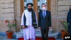 This handout photo released by the Taliban Foreign Ministry shows Taliban Foreign Minister Amir Khan Muttaqi posing with China's Foreign Minister Wang Yi in Kabul, March 24, 2022. (Taliban Foreign Ministry / AFP)