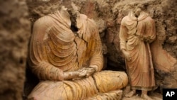 FILE - In this photograph made in Mes Aynak valley, southwest of Kabul, Afghanistan, Buddha statues are seen inside an ancient temple, Oct. 12, 2010.