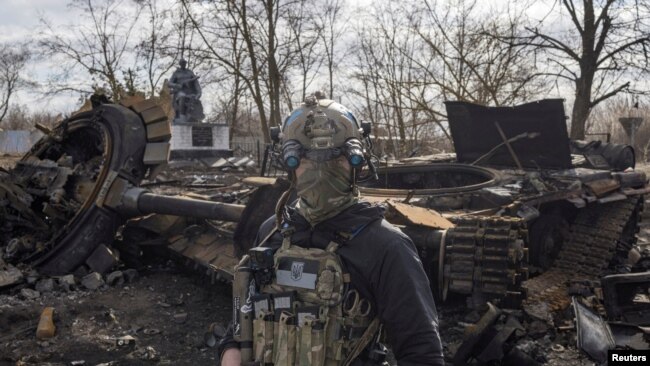 Un soldado ucraniano pasa junto a los restos de un tanque ruso en la aldea de Lukyanova, en las afueras de Kiev, mientras continúa la invasión rusa de Ucrania, el 27 de marzo de 2022.