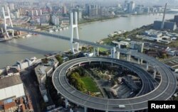 Pemandangan dari udara menunjukkan jembatan di atas sungai Huangpu, di tengah pembatasan lalu lintas dan lockdown di daerah Pudong di tengah pandemi COVID-19 di Shanghai, Cina, 29 Maret 2022. Gambar diambil dengan drone. (REUTERS/Aly Song)