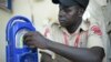 FILE — A security guard listens to the radio while at work at the South Sudan's 'Eye Radio' station premises in the South Sudan capital Juba on March 2, 2019. 