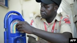 FILE - A security guard sits listening to the radio while at work at the "Eye Radio" station premises in Juba, South Sudan, March 2, 2019.