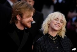 FILE - Finneas O'Connell, left, and Billie Eilish poses for photographers upon arrival for the World premiere of the new film from the James Bond franchise "No Time To Die," in London, on Sept. 28, 2021. They will perform a musical number at the 2022 Osca