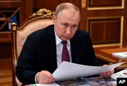 Russian President Vladimir Putin attends a meeting in Moscow, Russia, March 21, 2022. (Mikhail Klimentyev, Sputnik, Kremlin Pool Photo via AP)