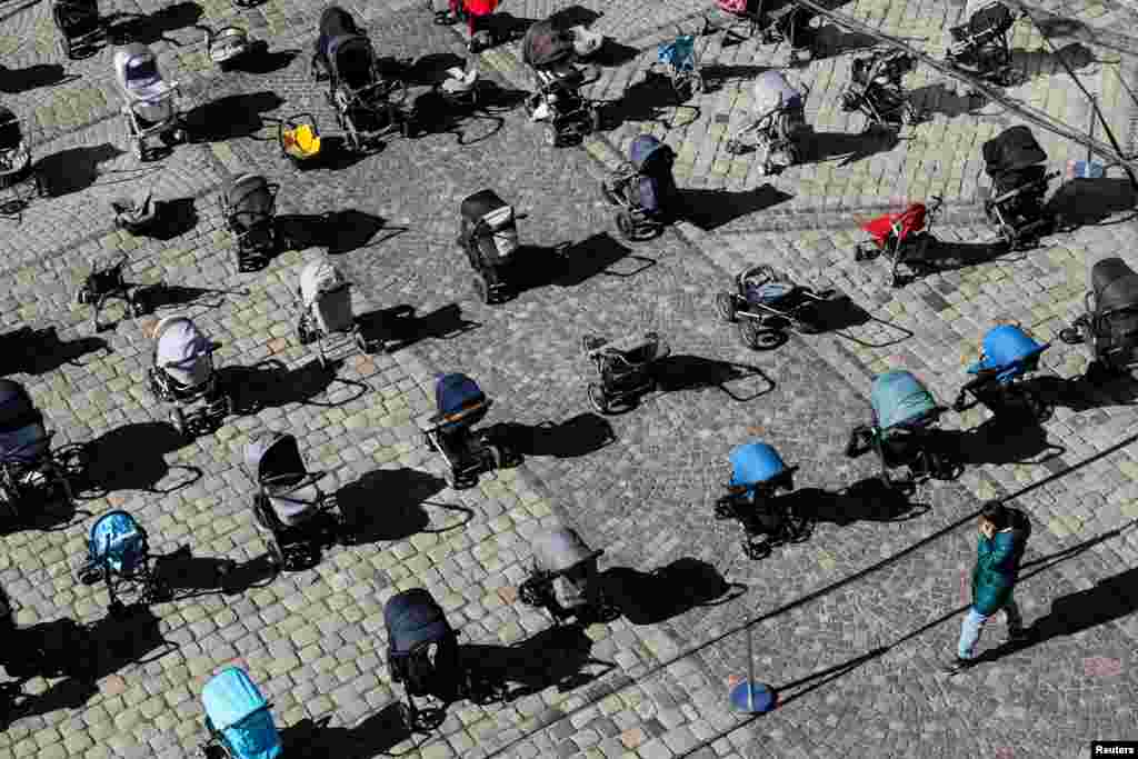 A person looks at 109 empty baby carriages placed in the center of Lviv, Ukraine, to highlight the large number of children killed in ongoing Russia&#39;s invasion of Ukraine.