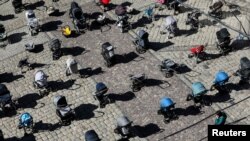 FILE - A person looks at 109 empty baby carriages placed in the center of Lviv, Ukraine, to highlight the large number of children killed in ongoing Russia's invasion of Ukraine.