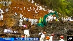 In this image taken from video footage run by China's CCTV, search and rescue workers and heavy machinery continue search operations at the China Eastern flight crash site in Tengxian County, March 25, 2022. 