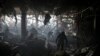 Ukrainian firefighters and servicemen search for people under debris inside a shopping center after a bombing in Kyiv, Ukraine, March 21, 2022. 