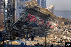 People examine the damage after shelling of a shopping center, in Kyiv, Ukraine, March 21, 2022.