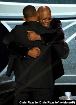 Will Smith, left, and Samuel L. Jackson hug in the audience as Will Smith is announced the winner of the award for best performance by an actor in a leading role for "King Richard" at the Oscars on Sunday, March 27, 2022.